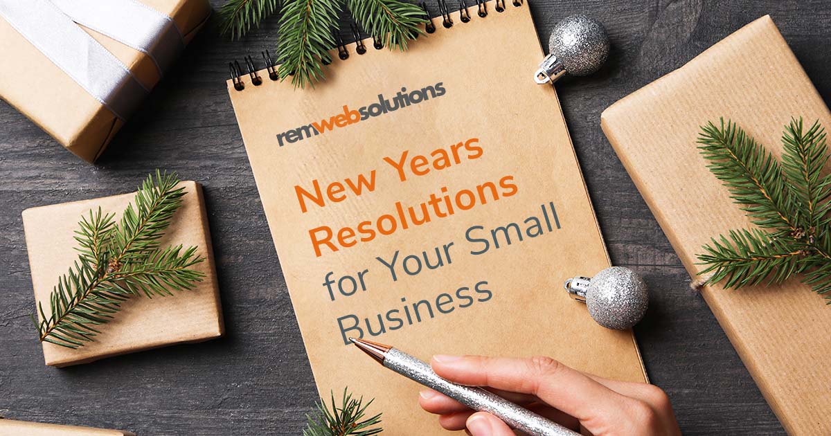 A woman's hand on top of a brown notebook with holiday decorations around it